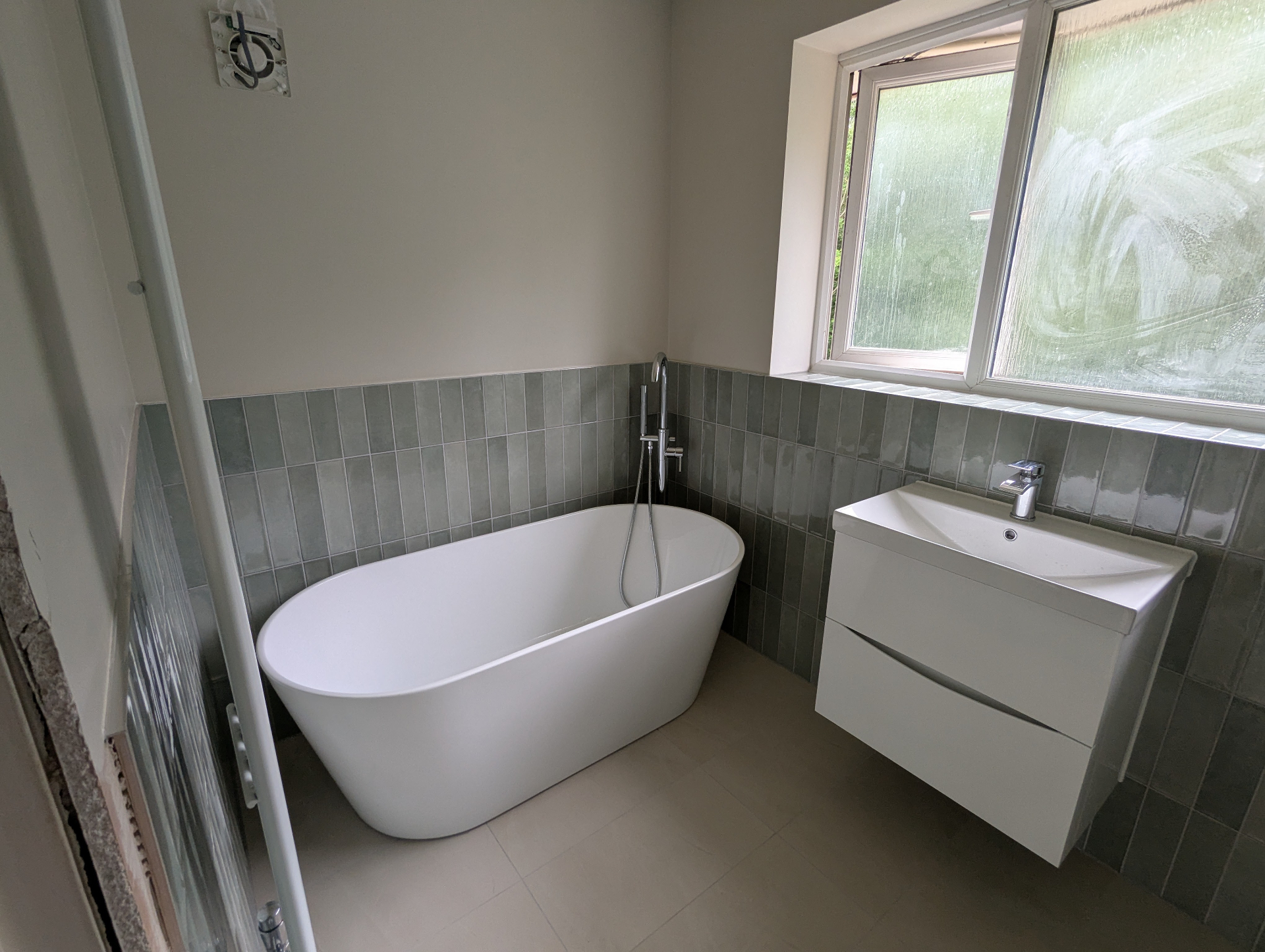 Modern grey bathroom renovation with LED mirror and chrome fixtures